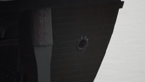 galleon andalucia replica ship detail tilt shot of the rudder, stern, captain cabin, flag pole and spanish flag while docked in valencia in slow motion 60fps