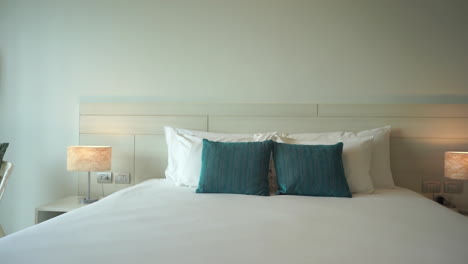 a tropical themed hotel room with ocean highlight and neutral colors has a large and inviting bed