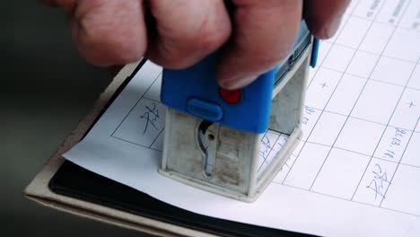 engineer writing date, signature and putting stamp on technical documents