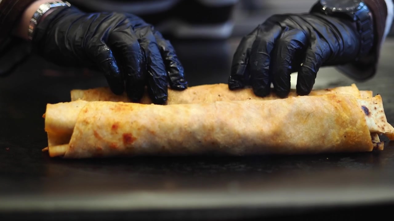 Koki Menekan Tortilla di Atas Wajan Panas