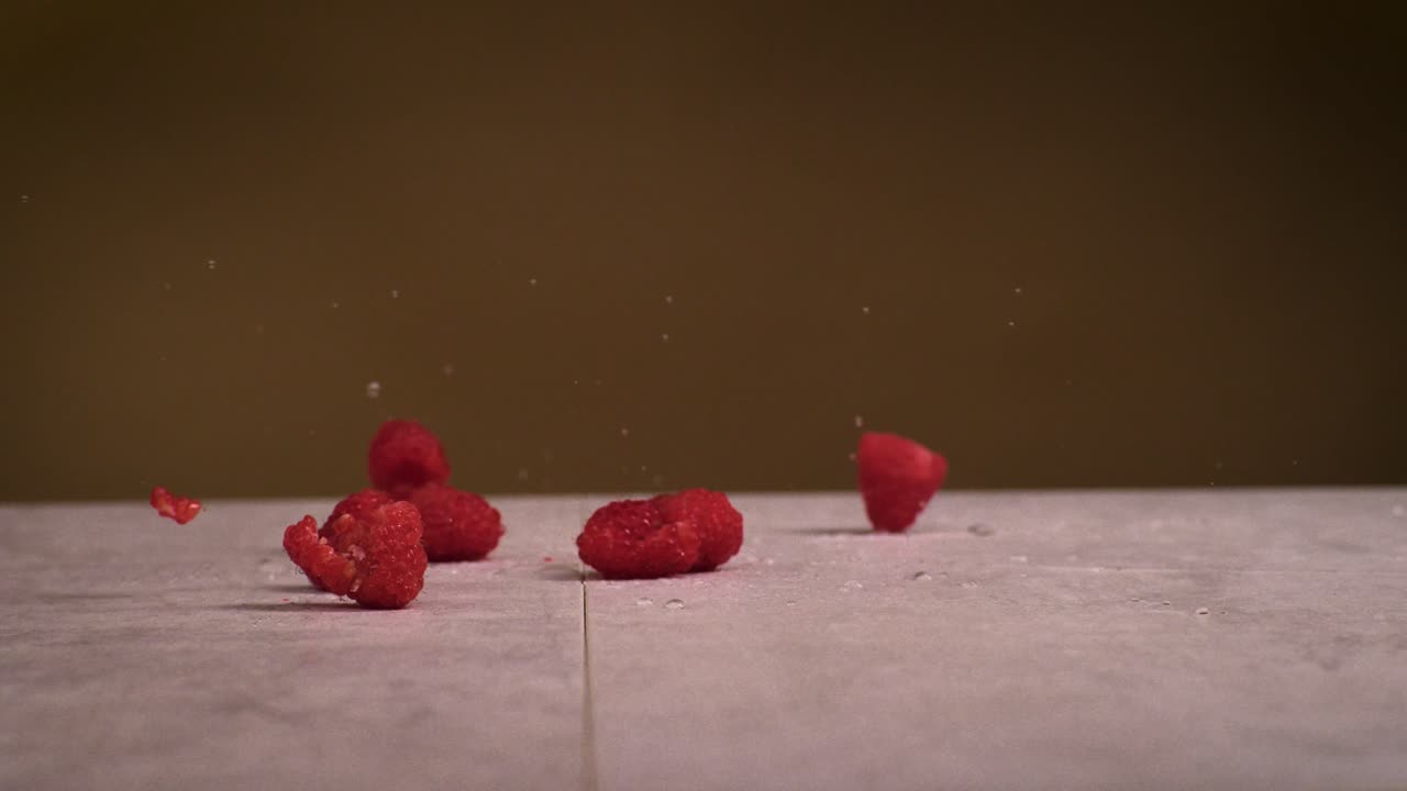 라즈베리가 표면에 떨어지고 물이 곳곳에 스플래시됩니다. 슈퍼 슬로우 모션으로 1000fps 4k 충격