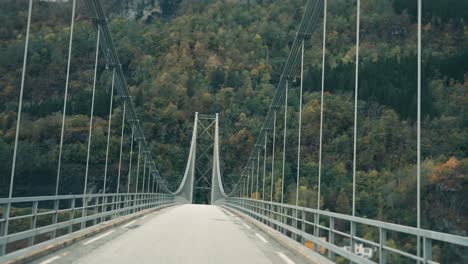 Conduciendo-Por-El-Estrecho-Puente-Colgante-Sobre-El-Fiordo-De-Hardanger-Y-Hacia-Las-Montañas-Cubiertas-De-Bosques