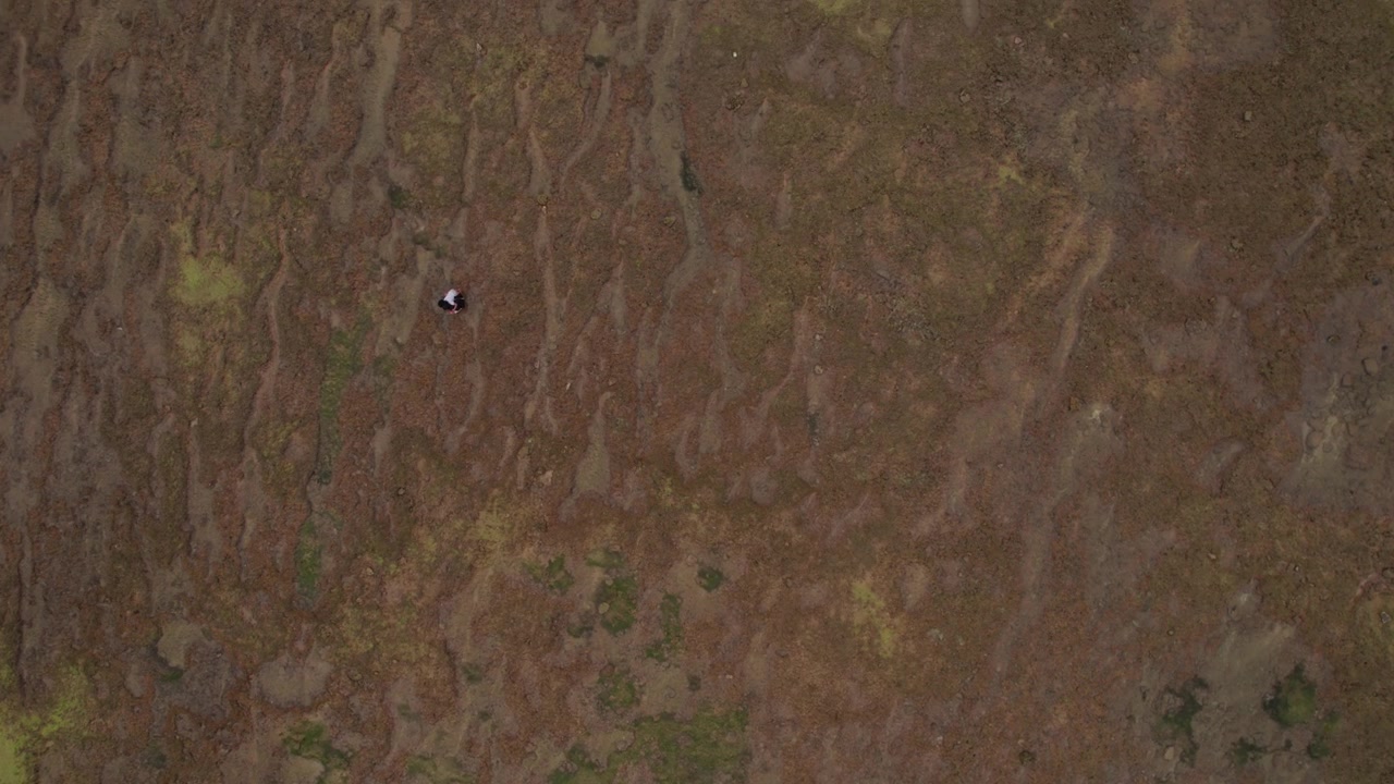Droneperspektiv ovenfra fanger kupert terreng og abstrakte naturmønstre i et avsidesliggende landskap, som viser tekstur, geologi og miljø i Marokko.