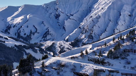 Drone-lifting-shot-of-snow-covered-mountain-ridges-Adelboden-on-a-sunny-winter-day