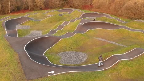 eboarder fährt auf einem bmx-pumptrack herum