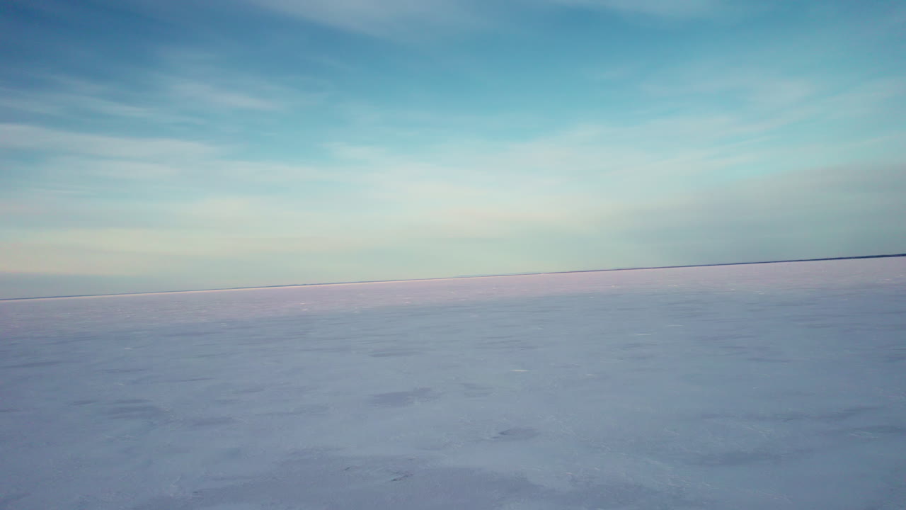drone volando sobre un lago congelado en canadá en la hora dorada