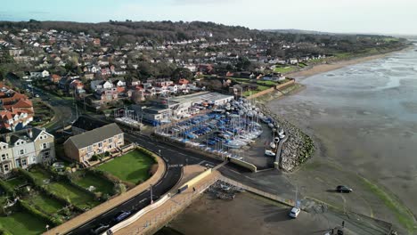 west kirby sailing club, wirral en una mañana soleada - drone aéreo girar en el sentido de las agujas del reloj centrándose en el astillero y la casa del club