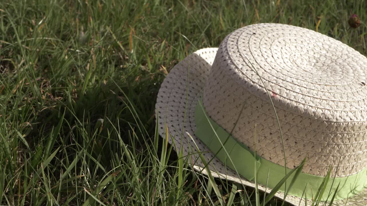 Straw hat left in the grass close up shot
