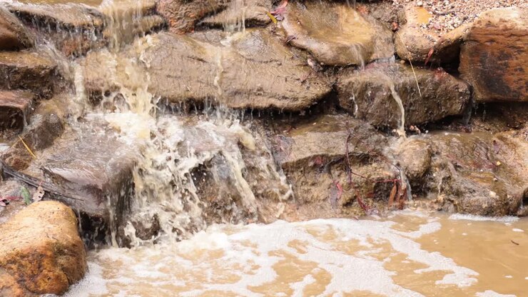 Acqua che scende a cascata sulle rocce in un ruscello