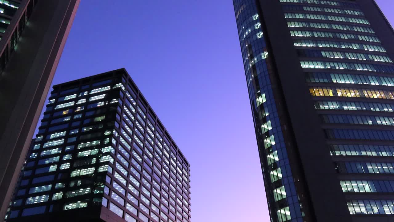 Purple sunset evening sky with tall skyscraper buildings in Tokyo city Japan, 4K tilting up