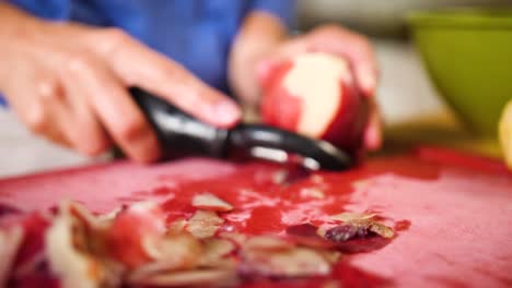 close-up-hands-using-a-peeler-to-peel-a-peach-for-baking-a-pie