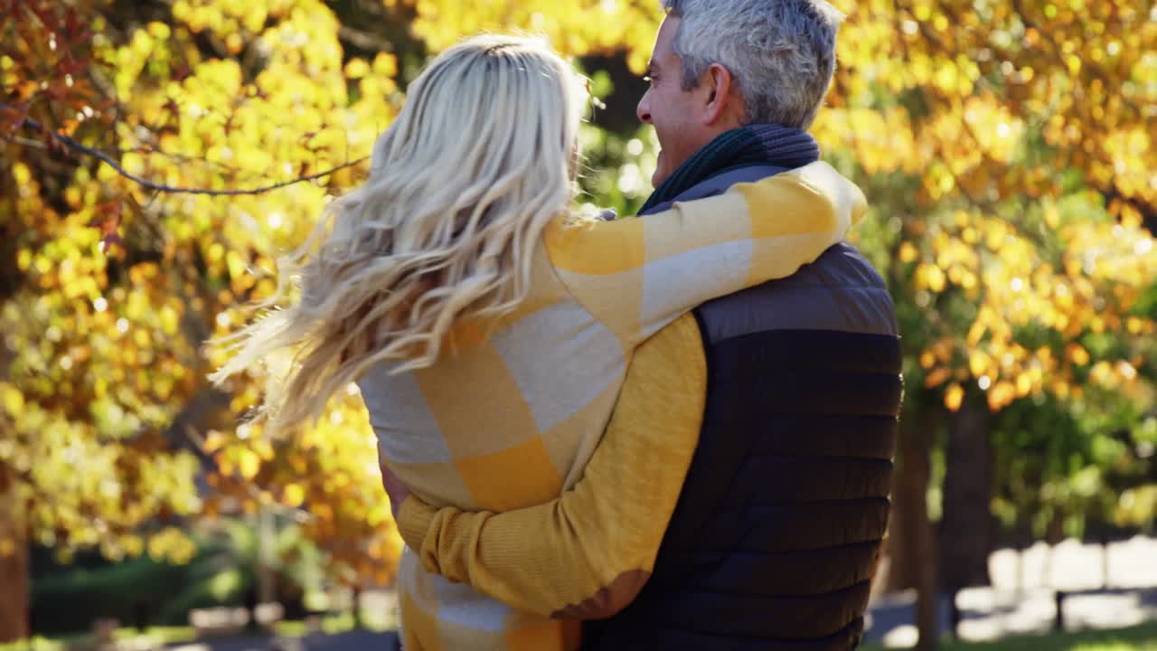 hombre levantando y girando esposa al aire libre