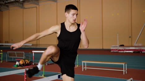 male athlete jumping hurdles