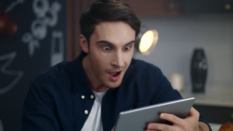 focused businessman reading project results on tablet computer at home office.