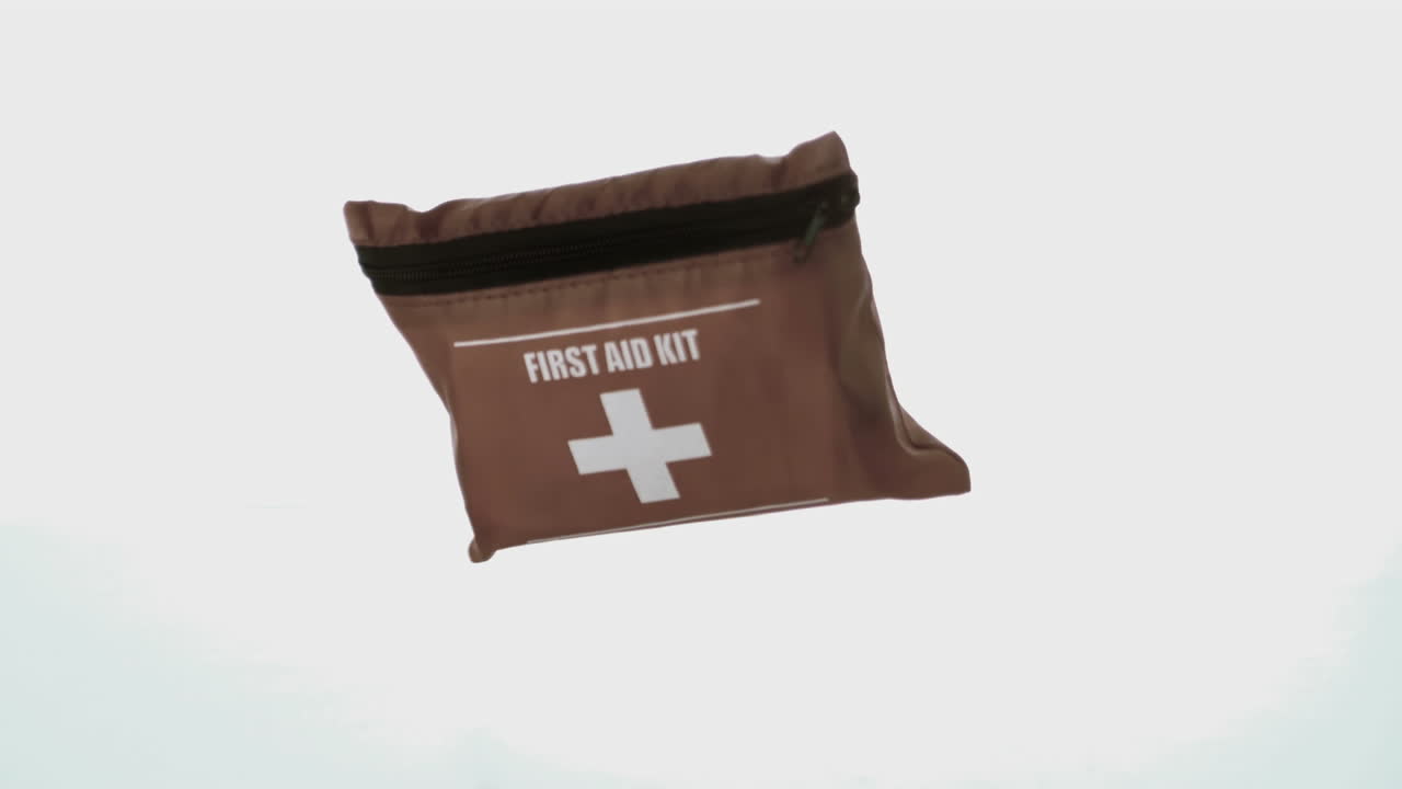 First aid kit falling on white background