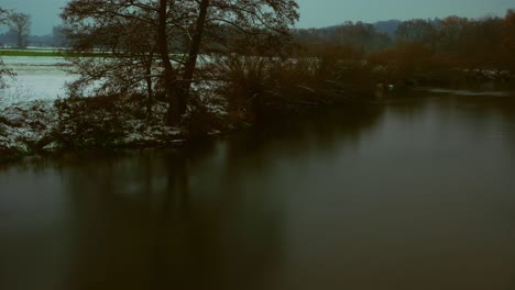 reflections and snow on a riverbank