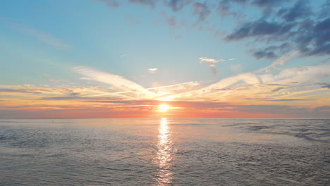 Una-Marea-Baja-Tranquila-En-La-Playa-Cerca-De-La-Barrera-De-Marejada-En-El-Suroeste-De-Los-Países-Bajos,-Durante-La-Puesta-De-Sol