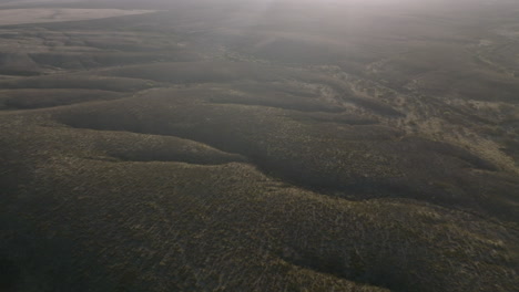 Aerial-footage-flying-across-the-Arizona-desert-in-the-morning-sun-showing-the-hills-and-gulleys-and-waterways-of-the-land