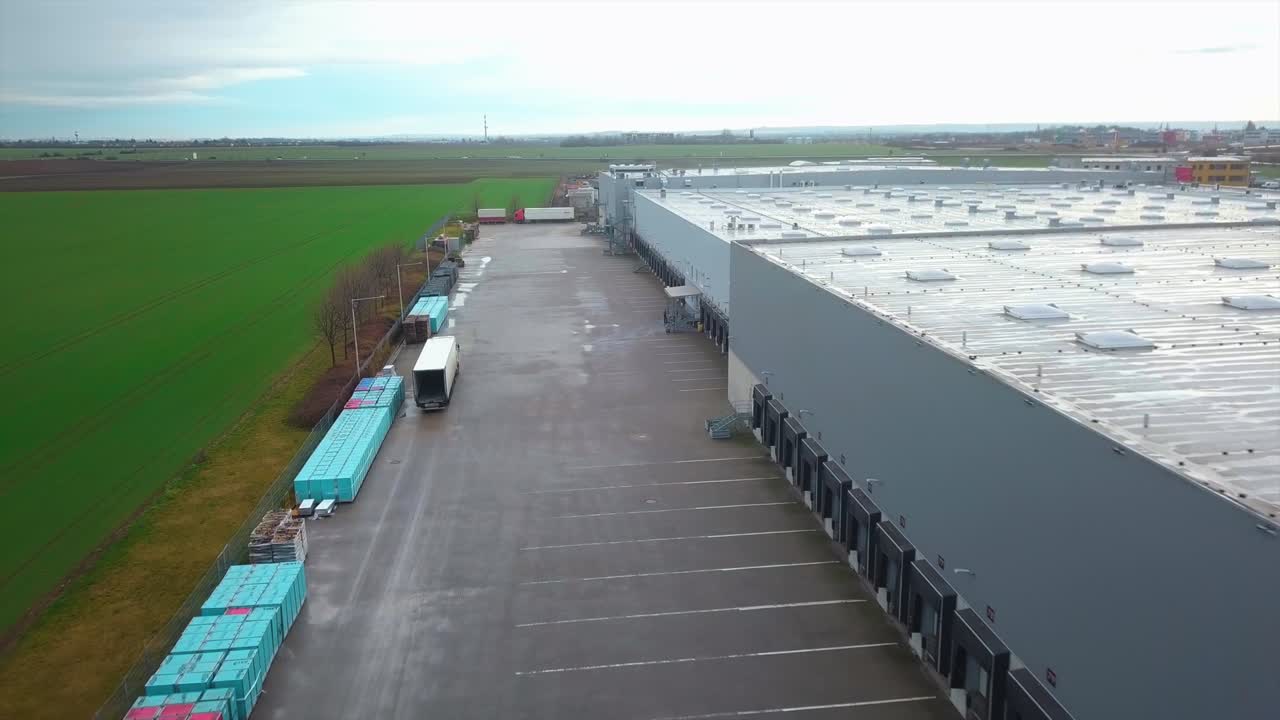 Aerial view of a cargo truck moving next to an empty industrial parking lot