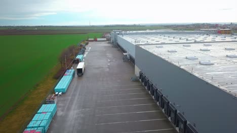 aerial view of a cargo truck moving next to an empty industrial parking lot