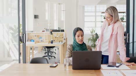 Busy-diverse-businesswomen-discussing-work-with-laptop-in-office-in-slow-motion