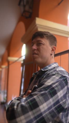 young man in a plaid shirt, posing in an urban setting