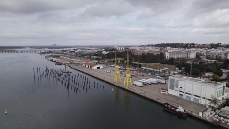 Yellow-cranes-on-dock-at-Port-of-Huelva-on-Odiel-river,-Spain