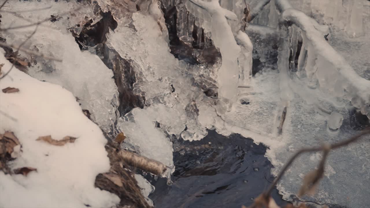agua que fluye a través de la nieve derretida en vallee bras-du-nord en quebec, canadá en invierno - toma de cámara estática