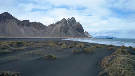 drone stokksnes vestrahorn sobre playa de arena negra