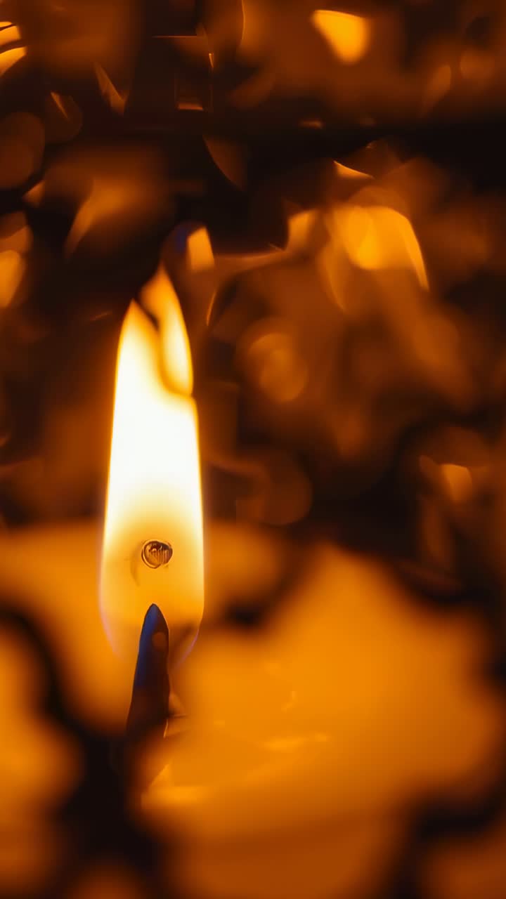 Vertical video: Flickering candle flame behind metal lattice inside room from air currents
