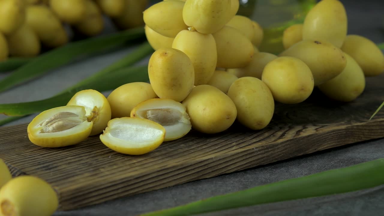 las palmeras de dátiles frescas se colocan en la mesa con aceite, concepto de alimentos saludables. palmeras de dátils. frutas crudas de palmieras de dátiles (phoenix dactylifera)