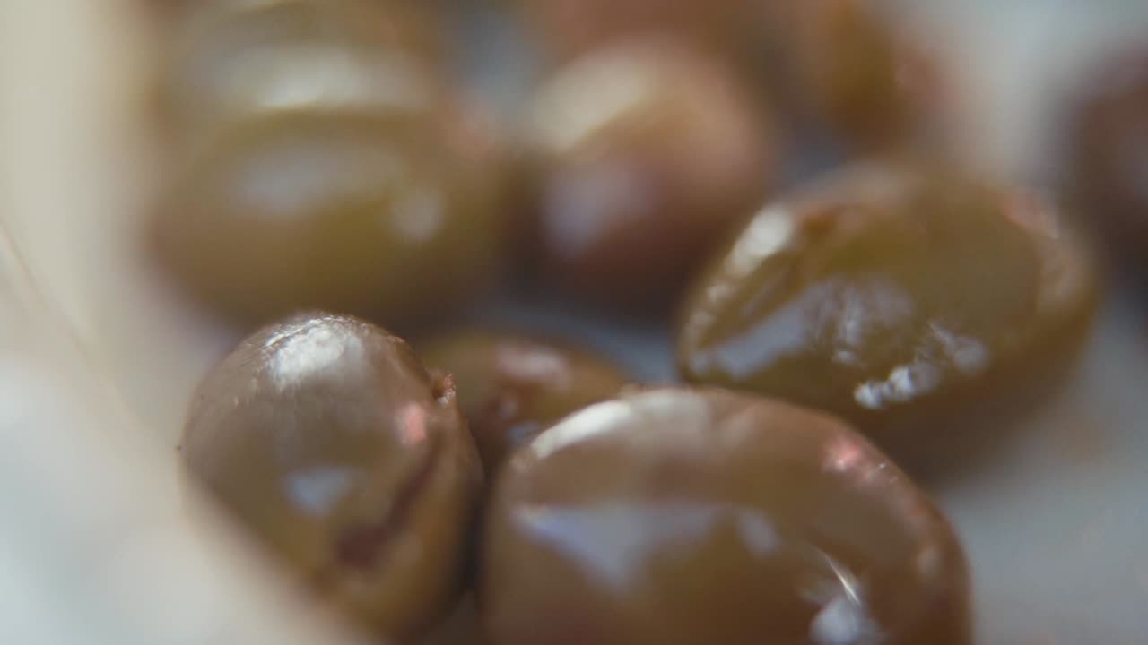 video macro de primer plano de una pila de aceitunas verdes con aceite de oliva