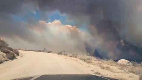 california wildfires 2022, dark smoke and vapors above land, driver's pov from suv vehicle moving on dusty road