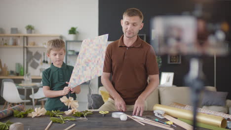 father and son making a paper kite together