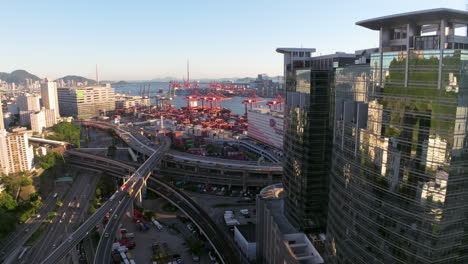 Ascending-drone-shot-of-Container-Port-with-Cranes-and-traffic-on-bridges-in-Hong-Kong-on-a-clear-day