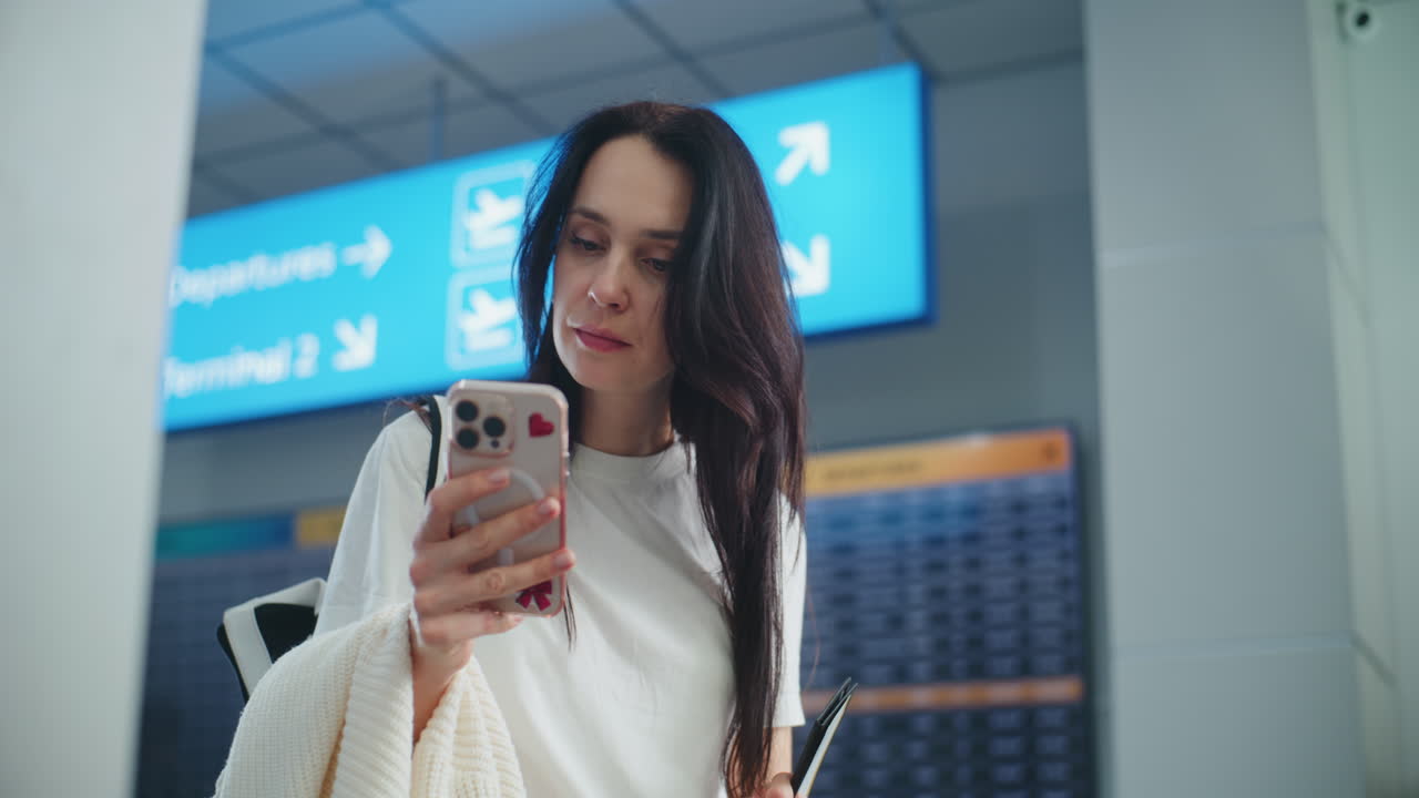 Woman Checking Flight Information at Airport
