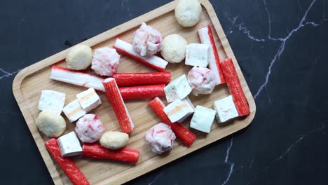 surimi variados y pasteles de pescado en tabla de madera