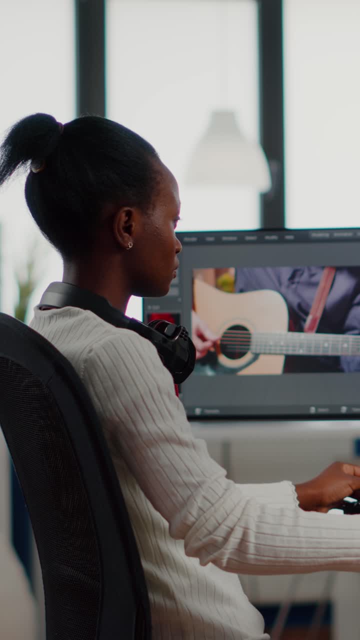 Vertical video African video editor looking at camera smiling editing video project