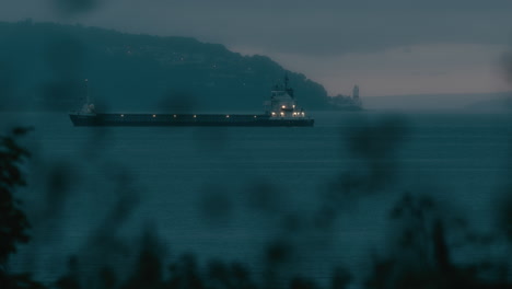empty container ship waiting in bay, seen from the land in the evening. coastal scene.