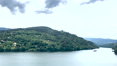 Ferry-Que-Trae-Turistas-Que-Disfrutan-Del-Momento-En-El-Río-Duero-En-Un-Día-Nublado,-En-Aguas-Tranquilas-Y-Tranquilas