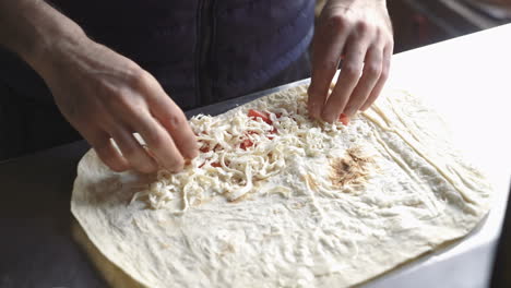 Lavash rolls with cheese and tomatoes. ?hef turns the pita with stuffing. Healthy breakfast concept.