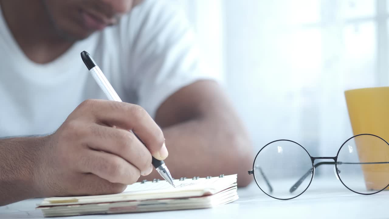 persona que escribe en un bloc de notas