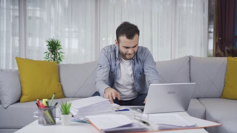 Young-man-working-from-home-is-very-tired,-his-wrists-and-hands-hurt.