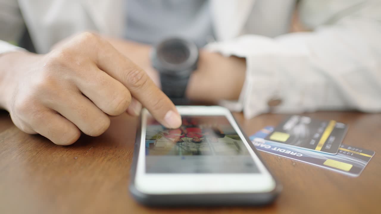 un joven empresario con una máscara quirúrgica está tomando una videoconferencia con los clientes a través de un teléfono inteligente conectado a internet.