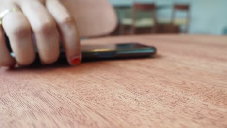 woman using phone at a cafe table