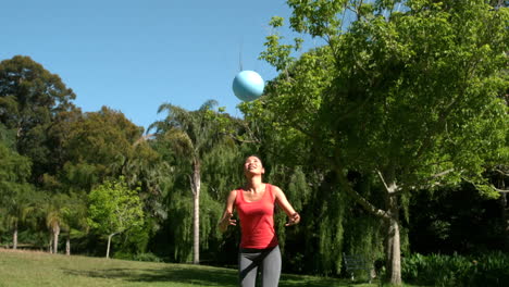 Sporty-brunette-playing-football