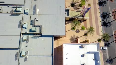 Vista-Aérea-Mirando-Hacia-El-Techo-Del-Edificio-Comercial,-Inspeccionando-Las-Unidades-De-Hvac