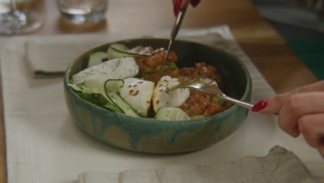 bowl of gourmet salad with vegetables and cheese being prepared