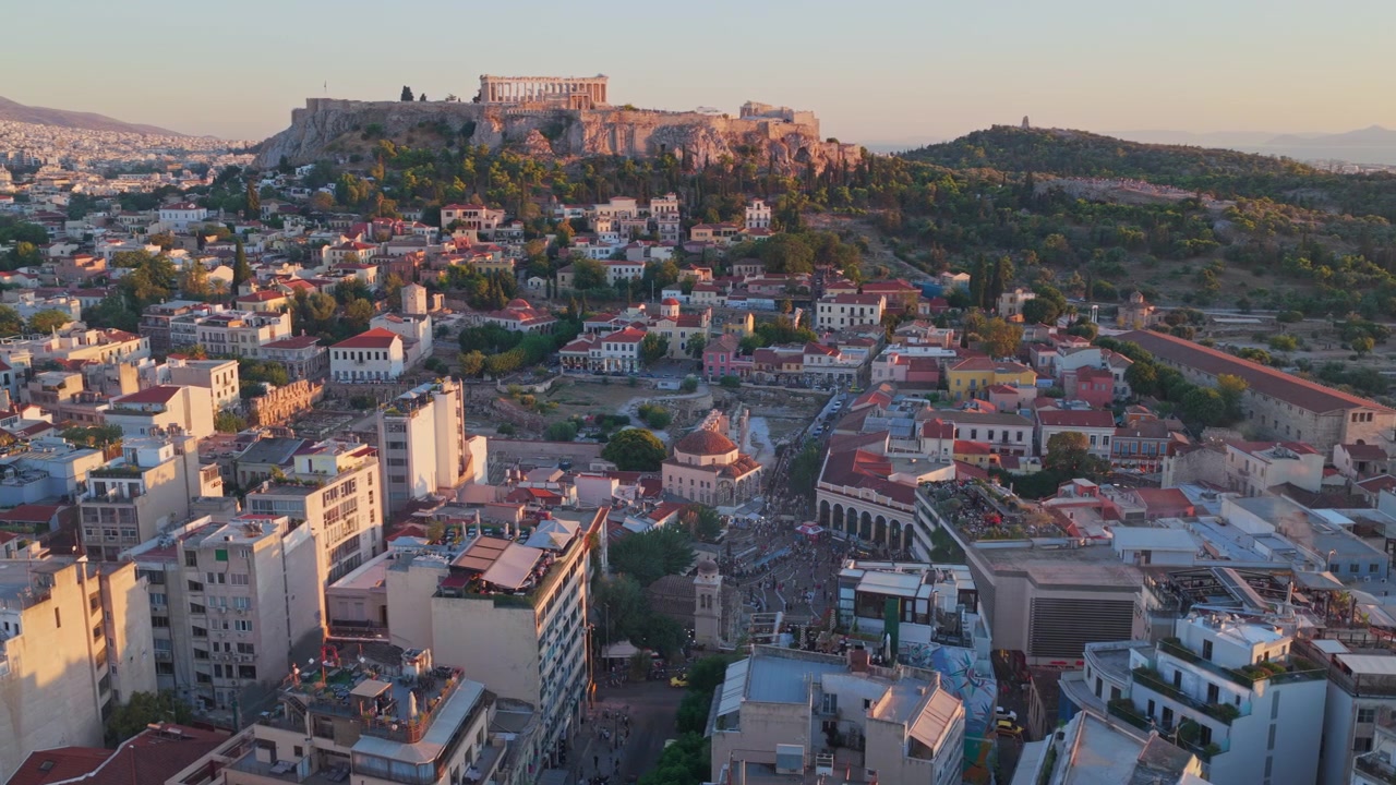 Vista aérea magnífica da antiga Acrópole de Atenas e da cidadela do Partenon, graciosamente situada em um afloramento rochoso acima da cidade moderna durante um belo e quente pôr do sol