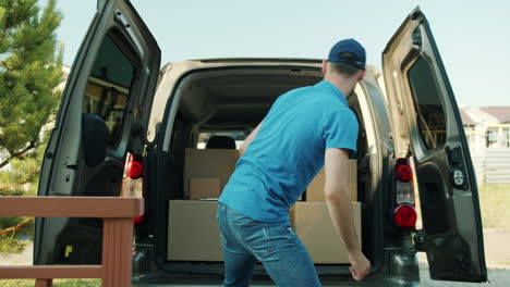 delivery person loading boxes into a van